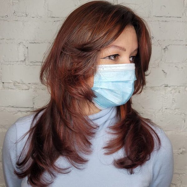 Fresh Feathered Hair with Copper Color - A woman with surgical facemask wearing a blue turtle neck sweater