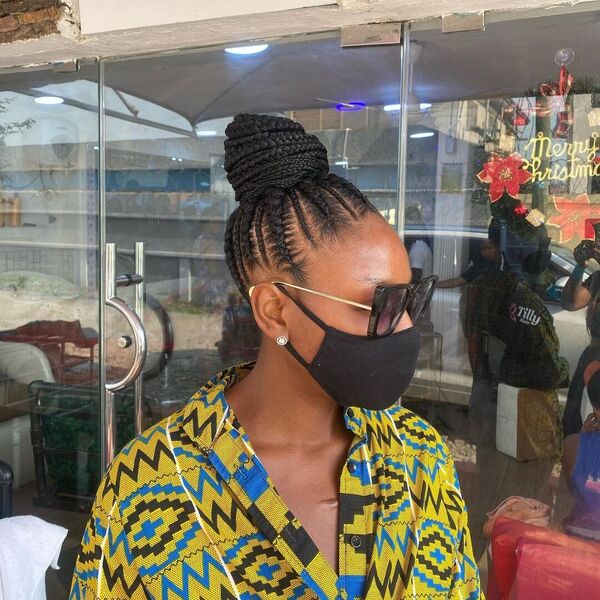 Ghana Cornrows Braid with Bun - A woman with sunglasses wearing a black facemask