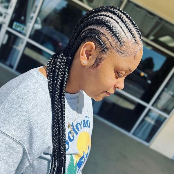 Goddess Feed-In Cornrow Braids - A woman wearing a gray printed sweater