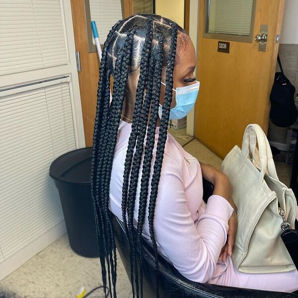 Large Knotless Braids - A woman wearing a surgical facemask