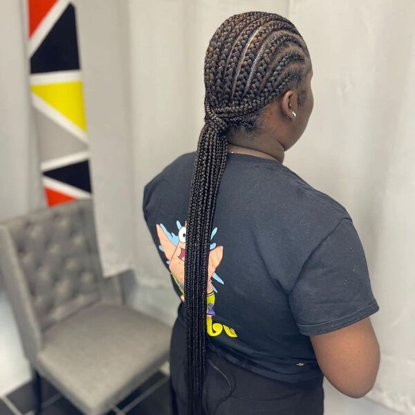 Long African Cornrow Hairstyle - A woman wearing a black printed shirt