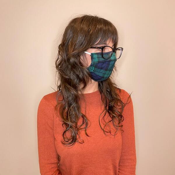 Long and Shaggy Layered Hairstyle - a woman wearing a face mask