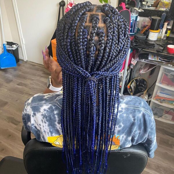 Medium Box Braids with Ombre Color - A woman wearing a tie dye shirt