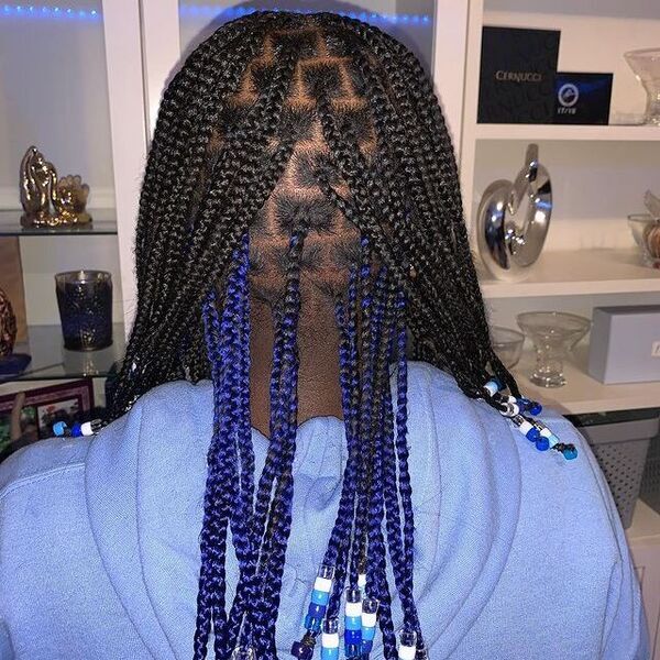 Medium Knotless Braids with Blue Beads - A woman wearing a blue hooded jacket