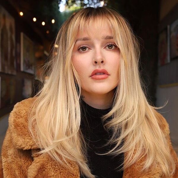 Shaggy Golden Blonde Hairstyle - a woman wearing a coat