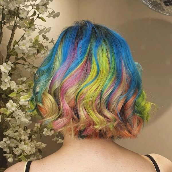 Short and Curly Lob Cut Rainbow Hair Color - A woman wearing a black spaghetti strap