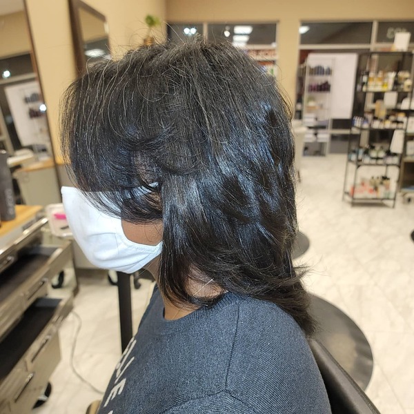 Short Feathered Flip Hair - A woman wearing a white facemask