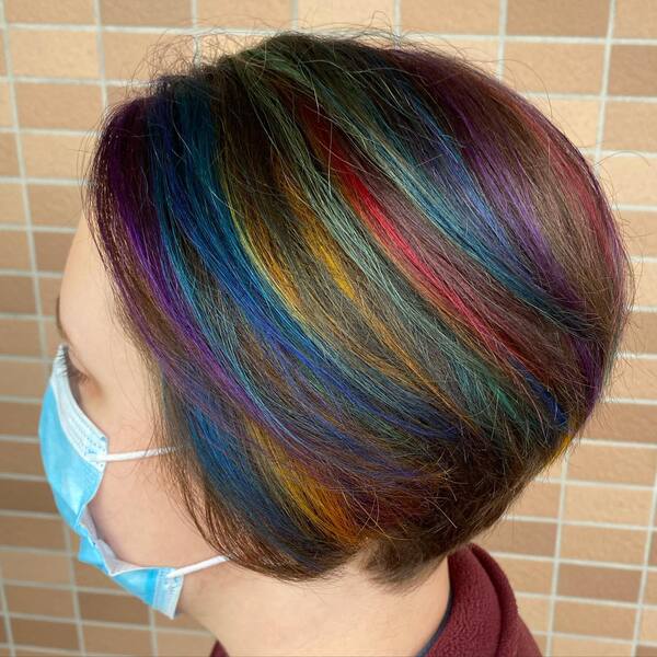 Short Hair Rainbow Highlights - A woman wearing a blue surgical facemask
