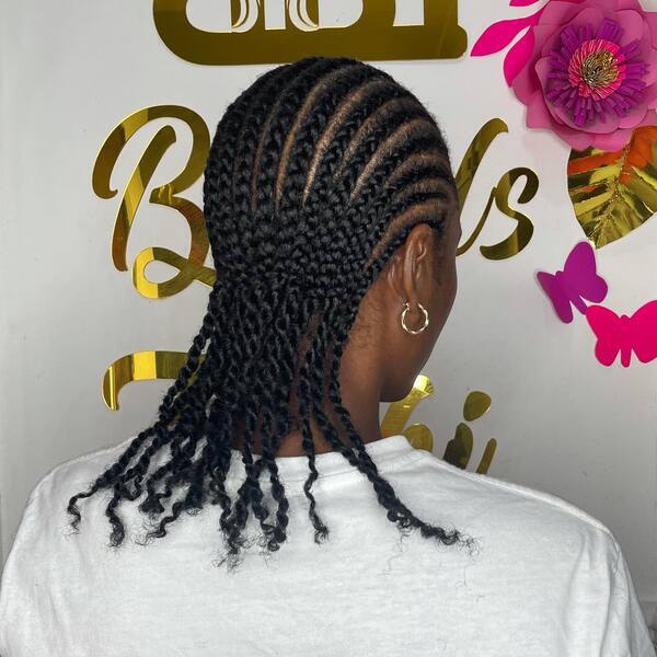 Simple Cornrow with Natural Extensions - A woman with earrings wearing a white shirt