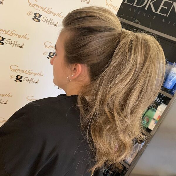 Sleek and Classy Ponytail with Blonde - A woman wearing a black cape