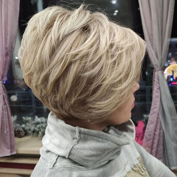 Bob Feathered Cut with Light Blonde - A woman wearing a gray turtle neck sweater