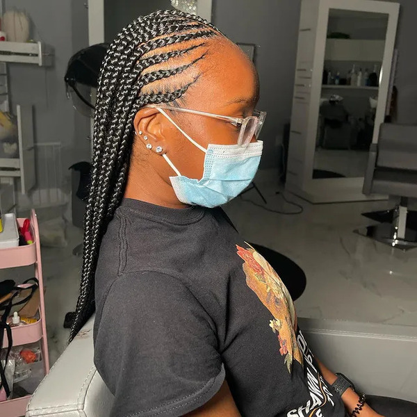 Two Layered Feed In Braids - a woman wearing a face mask