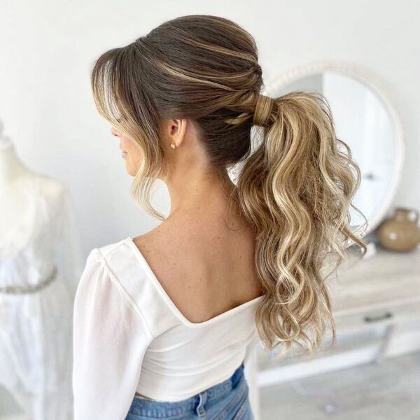 Voluminous Ponytail Updo with Bangs - A woman wearing a white crop top