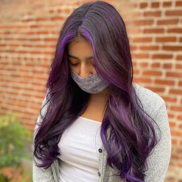 Black and Purple Shades in Wavy Hair - a woman wearing a gray mask