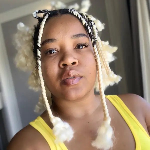 Blonde Box Braid Tendrils - a woman wearing a yellow sleeveless