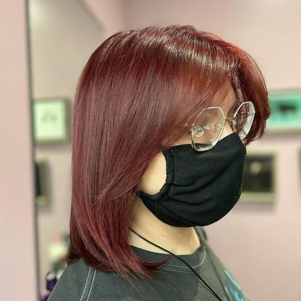 Bob Haircut with Brown and Reddish Hair - a woman wearing a face mask