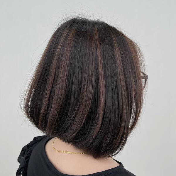 Bob Haircut with Chunky Highlights - a woman wearing a black dress