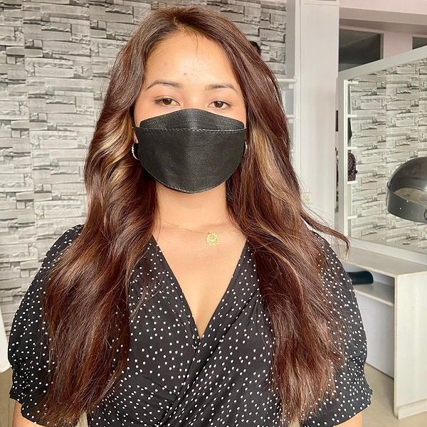 Brunette Hair with Highlights - a woman wearing a face mask