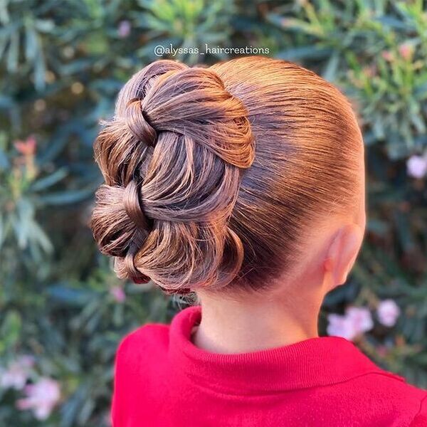 Four Strand Braided Bun - a girl wearing a pink polo shirt