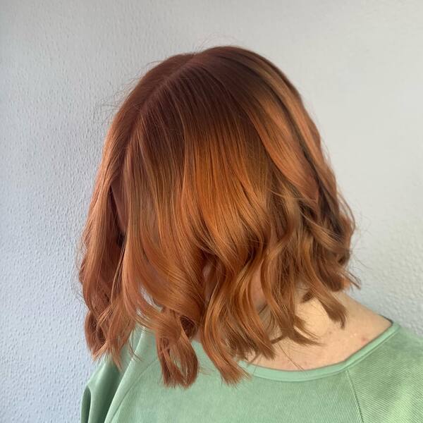 Ginger Hair Color in Layered Blunt Bob - a woman wearing a shirt