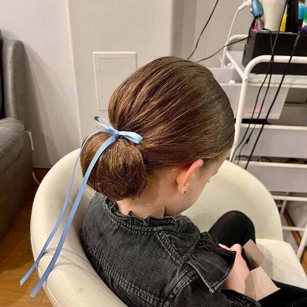 Low Bun Hairstyle with Blue Ribbon- A girl wearing black denim