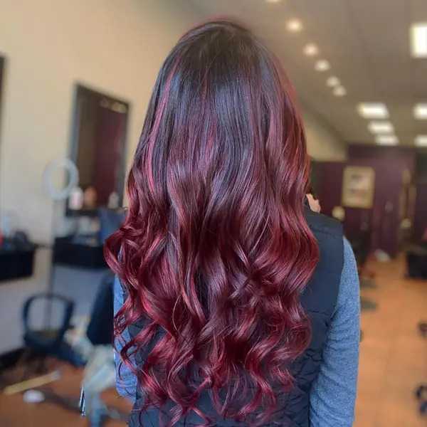 Mahogany Reddish Curls Ombre Hairstyle - a woman in a back view