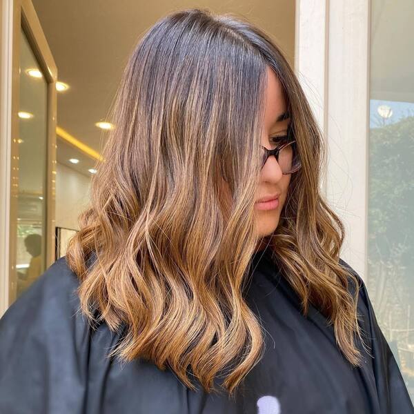 Ombre Wavy Almond Hairstyle - a woman wearing a black cape
