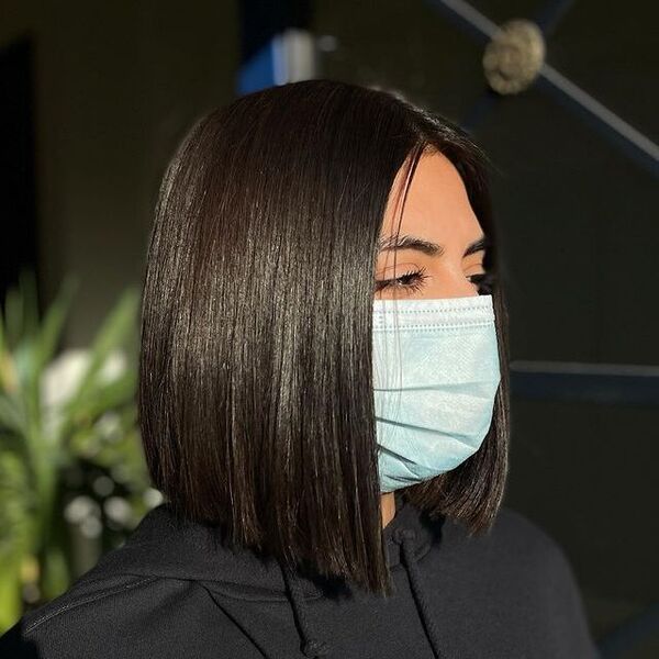 razor cut bobs - a woman wearing a face mask