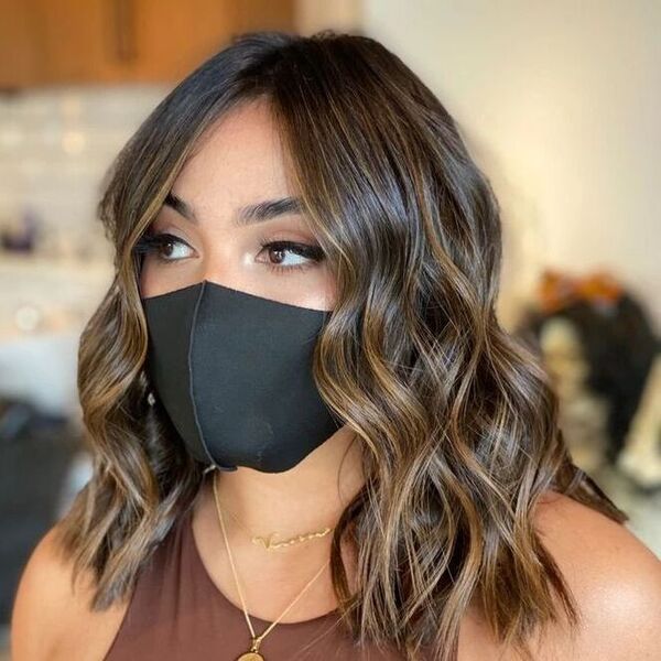 Short Haircut with Rich Brown Highlights - a woman wearing a black face mask