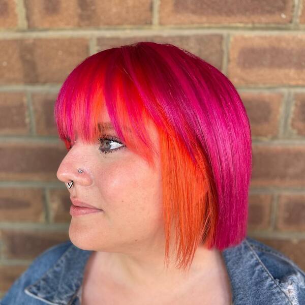 Stylish Bob with Orange Underlights - a woman wearing a denim jacket