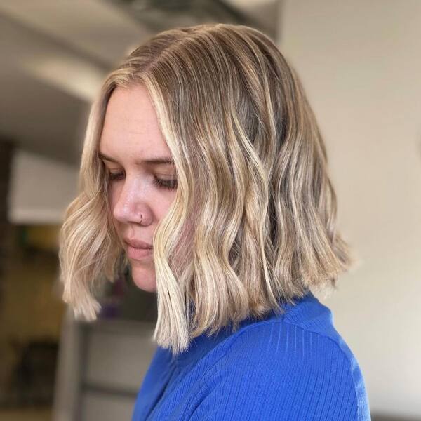 Textured Bob with Blonde Highlights - a woman wearing a blue dress