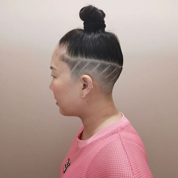 Top Bun with Undercut and Shaved Lines - a woman in a side view