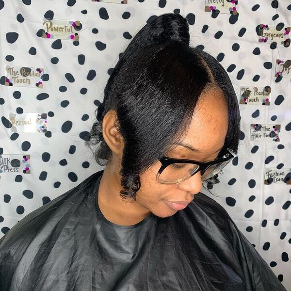 Ariana Ponytail with Curled Parted Bangs - a woman wearing glasses in salon cape