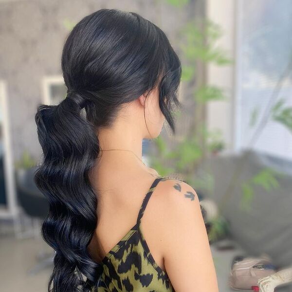 Jet Black Curled Pony and Bangs - a woman wearing animal print green top