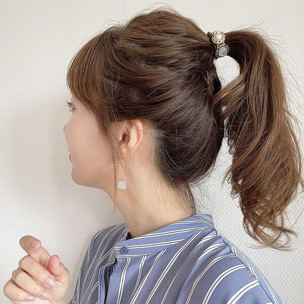 Messy Ponytail with Curtain Bangs - a woman wearing blue stripe polo