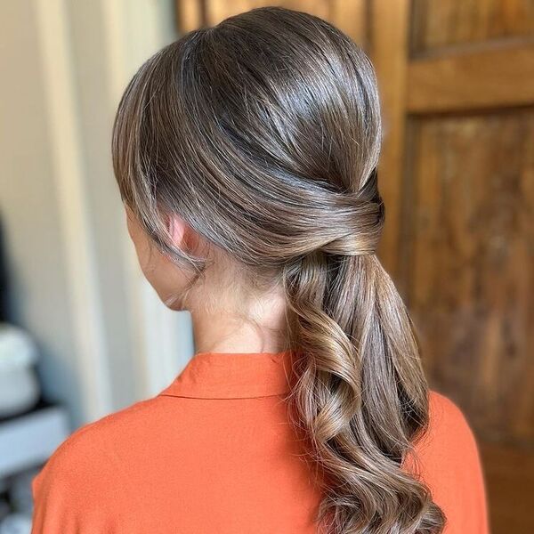 Side Curtain Bangs with Curled Ponytail - a woman wearing orange polo