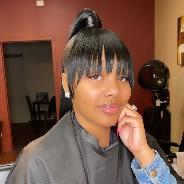 Straight Curtain Bangs with High Ponytail - a woman wearing black salon cape