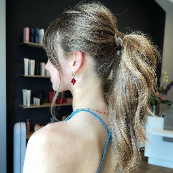 Textured Ponytail with Layered Bangs - a woman wearing blue sexy back top