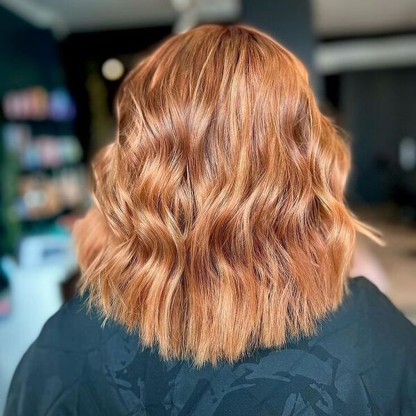 Copper Long Lob with Waves - a woman wearing salon cape