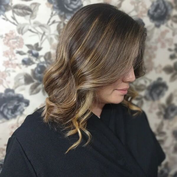 Curled Long Bob with Highlights - a woman wearing black salon robe