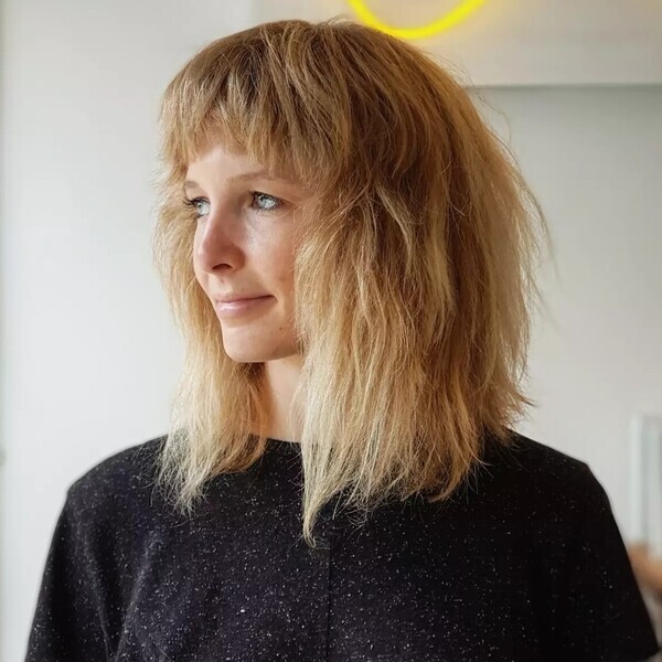 Frizzy Honey Shag Fringe Bob - a woman wearing glossy black top