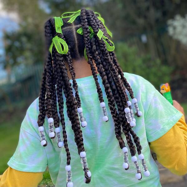 Long Braids with Beads - a woman wearing green dyed shirt