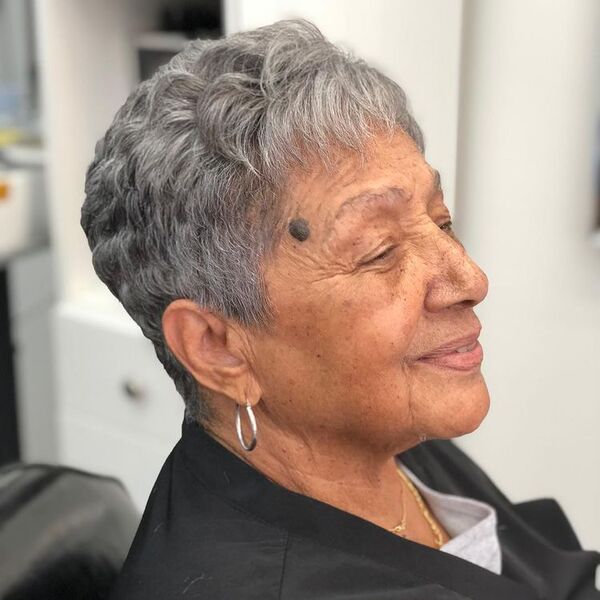 A woman wearing gray shirt with earrings