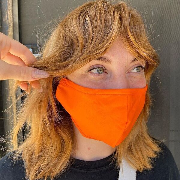 Natural Textured Hair and Fringe - a woman wearing orange mask