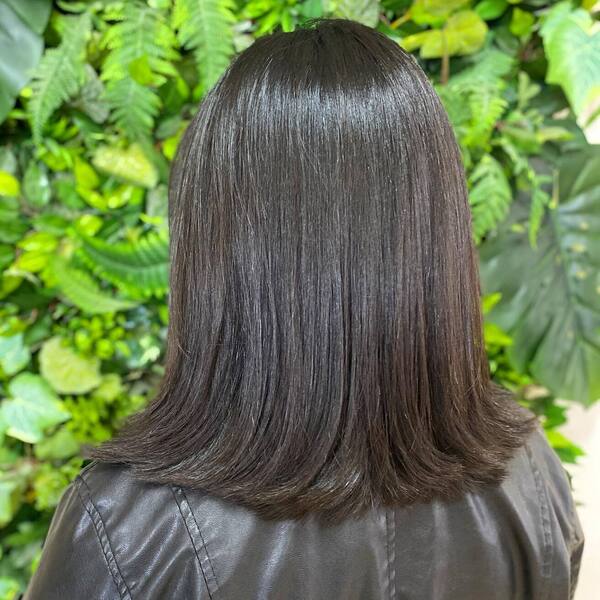 Shiny Long Bob with Choppy Ends - a woman wearing leather jacket