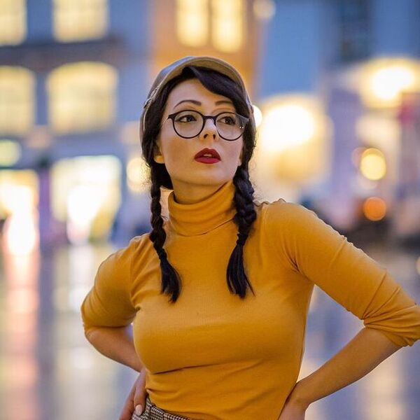 A woman wearing yellow turtle neck top