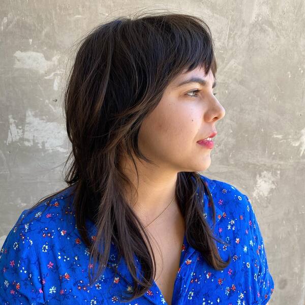 Short Fringe Razor Haircut - a woman wearing blue floral top