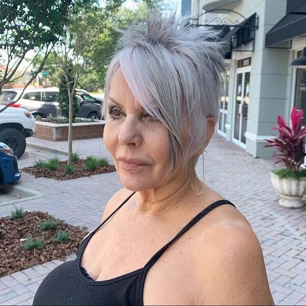 A woman wearing black string strap top and earrings