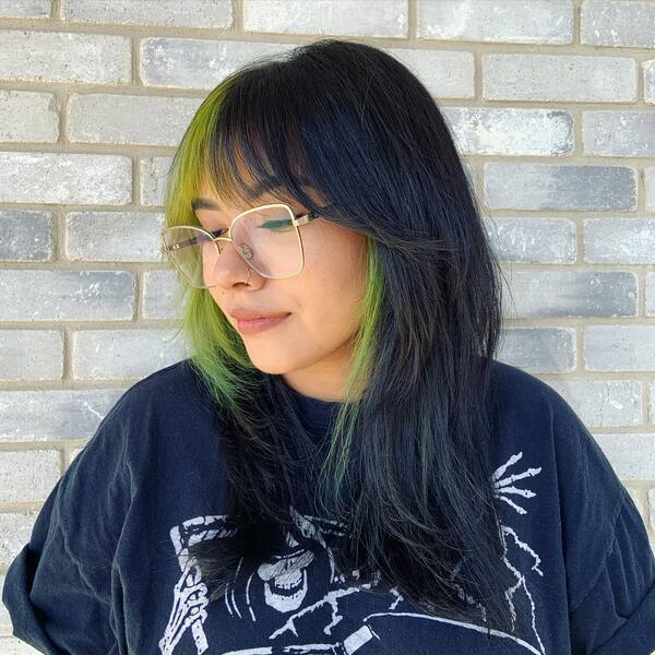 A woman wearing glasses in printed black shirt